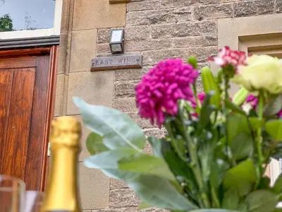 a vase of flowers in front of a building at Geltsdale Wing, Wetheral 1st floor apartment with countryside views, close to pub & restaurant in Wetheral