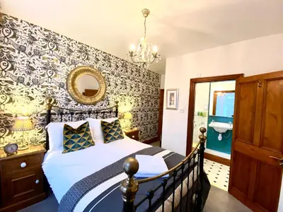 a bedroom with a bed and a wall with a mirror at Elm Tree Lodge in Keswick