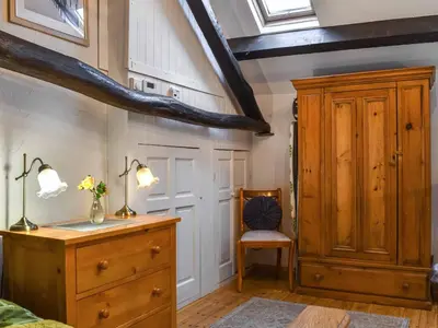 a bedroom with a wooden cabinet and a dresser at Swinside Cottage in Ennerdale Bridge