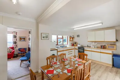 a kitchen and dining room with a table and chairs at Laghead Cottage in Gatehouse of Fleet