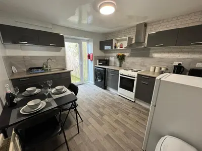 a kitchen with a table and a kitchen with a refrigerator at Scotch Terrace - 3 Bedrooms - Sleeps 6 in Whitehaven
