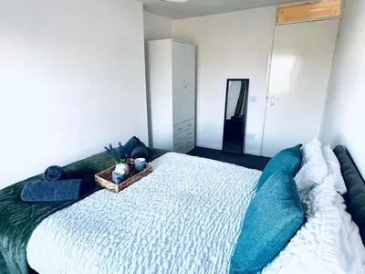 a bedroom with a large bed with blue pillows at The Georgian Townhouse - 4 Bedrooms - Sleeps 9 in Whitehaven