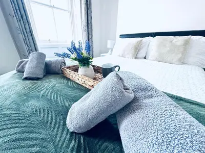 a bedroom with a bed with pillows and a basket on it at The Georgian Townhouse - 4 Bedrooms - Sleeps 9 in Whitehaven