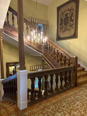 a staircase in a house with a chandelier at Moresby Hall Country House Hotel in Whitehaven