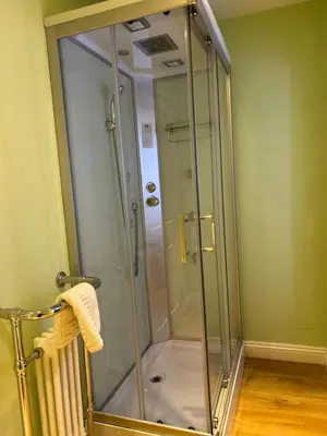 a shower with a glass door in a bathroom at Moresby Hall Country House Hotel in Whitehaven