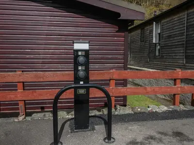 a parking meter sitting in front of a bench at Garden Cottage No 1 in Keswick