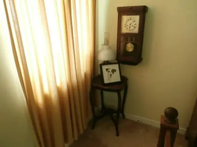 a room with a clock and a table with a lamp at Threecrofts Farm in Dumfries