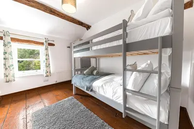 a bedroom with bunk beds and a window at Knott House Farm in Keswick