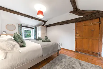 a bedroom with a large bed and a wooden dresser at Knott House Farm in Keswick