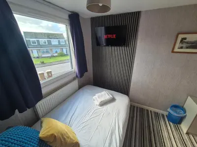 a small bed in a room with a window at Links Golf Villa in Troon