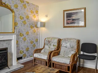 a living room with two chairs and a mirror at Montys in Castle Douglas