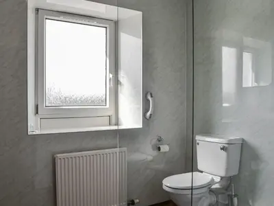 a bathroom with a toilet and a window at Montys in Castle Douglas