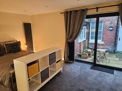 a bedroom with a bed and a view of a patio at Carlisle City Centre The Wash House in Carlisle
