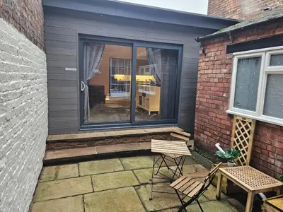 a patio with two chairs and a table and a window at Carlisle City Centre The Wash House in Carlisle