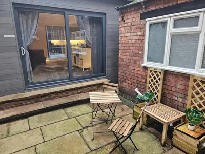 a patio with two chairs and a table and a window at Carlisle City Centre The Wash House in Carlisle