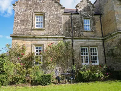 an old stone house with a table in front of it at The Pavillion in Carlisle