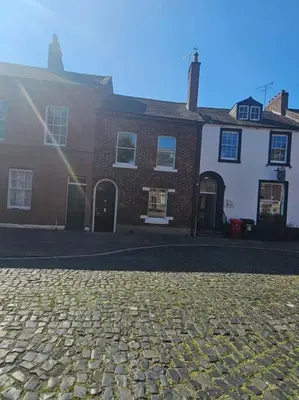a cobblestone street in front of a house at Carlisle City Centre. The Foremans Residence. in Carlisle