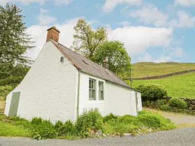 a white house with a chimney on top of it at High Auchenbrack in Thornhill