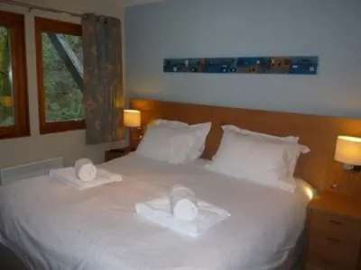 a bedroom with a white bed with two towels on it at Keswick Bridge 21, within walking distance of Keswick town centre, strictly no pets in Keswick