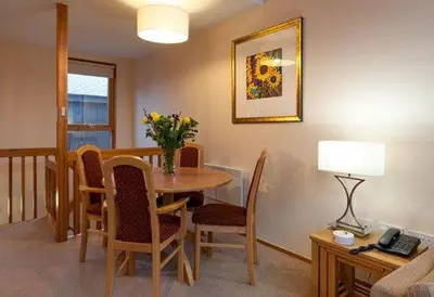 a dining room with a table with chairs and a lamp at Keswick Bridge 16, within walking distance of Keswick town centre, strictly no pets in Keswick