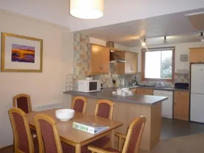 a kitchen with a wooden table and a table and chairs at Keswick Bridge 19, within walking distance of Keswick town centre, strictly no pets in Keswick