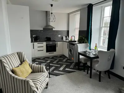 a kitchen with a table and chairs and a dining room at Lowther Apartment - 2 Bedrooms - Sleeps 4 in Whitehaven