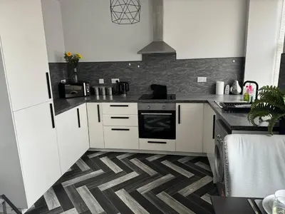 a kitchen with white cabinets and a stove at Lowther Apartment - 2 Bedrooms - Sleeps 4 in Whitehaven