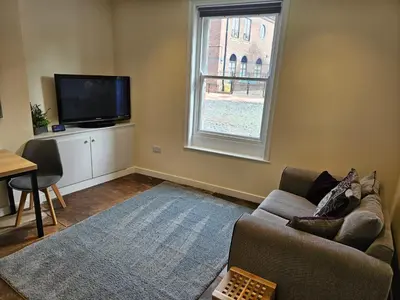 a living room with a couch and a tv and a window at Carlisle City Centre The Gavel in Carlisle