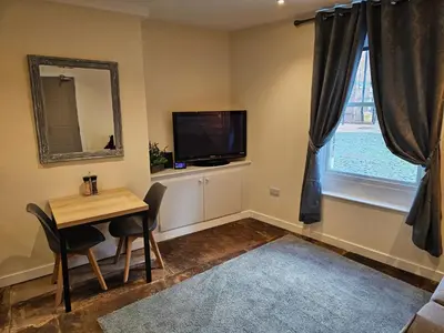 a living room with a table and a tv and a window at Carlisle City Centre The Gavel in Carlisle