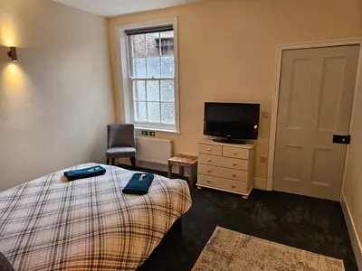 a bedroom with a bed and a tv and a window at Carlisle City Centre The Gavel in Carlisle