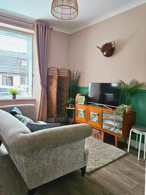 a living room with a couch and a tv at The Ferns - Modern Apartment With Parking & Shared Garden in Darvel