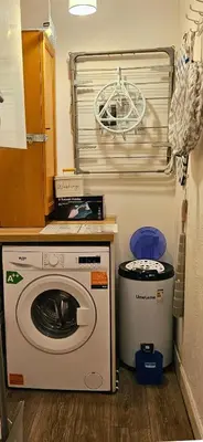 a washing machine and a trash can in a kitchen at The Ferns - Modern Apartment With Parking & Shared Garden in Darvel