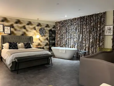 a bedroom with a bed and a bath tub and a tub at Loudoun Mains Luxury Lodges in Newmilns