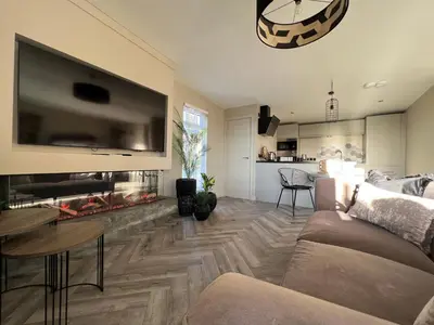 a living room with a couch and a large tv at Loudoun Mains Luxury Lodges in Newmilns