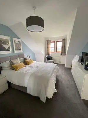 a bedroom with a large white bed with yellow pillows at Lanfine View 1 at Loudoun Mains with Hot Tub in Newmilns