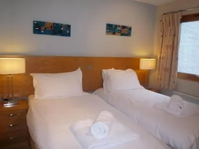 two beds in a hotel room with towels on them at Keswick Bridge 6, within walking distance of Keswick town centre, strictly no pets in Keswick