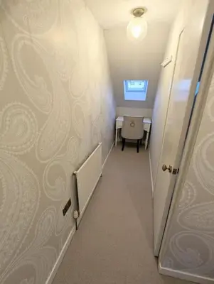 a hallway with a room with a table and a door at The Cottage @ 59 in Colmonell
