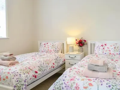 a bedroom with two beds and a table with a lamp at Paxville in Gretna