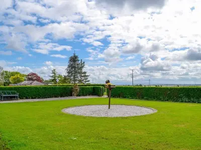 a park with a statue in the middle of the grass at Paxville in Gretna
