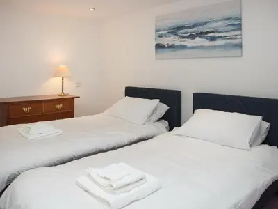 two beds sitting next to each other with towels on them at Criffel Cottage in Ruthwell