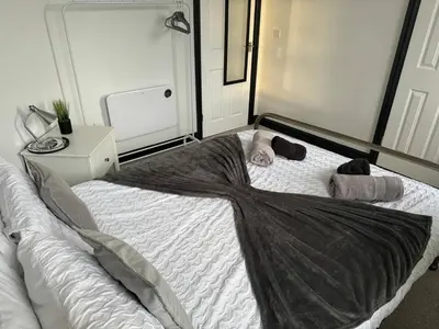 a bedroom with a large bed with towels on it at The Lowther Penthouse - 2 Bedrooms - Sleeps 4 in Whitehaven