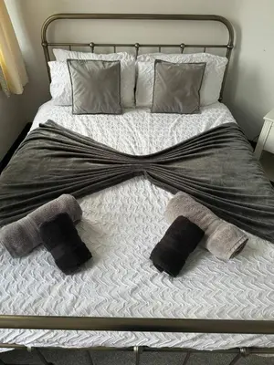 a bed with two mitts and towels on it at The Lowther Penthouse - 2 Bedrooms - Sleeps 4 in Whitehaven