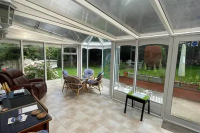 a screened in porch with a table and chairs at Number Fifty-Six Ramsey Villa in Ramsey