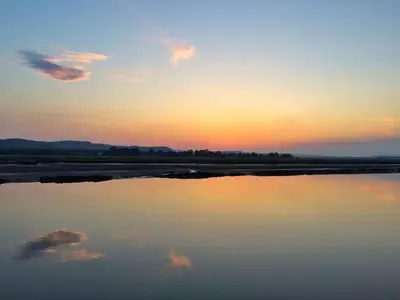 a reflection of the sky in the water at sunset at Shorepark - waterfront cottage with stunning views in Dumfries