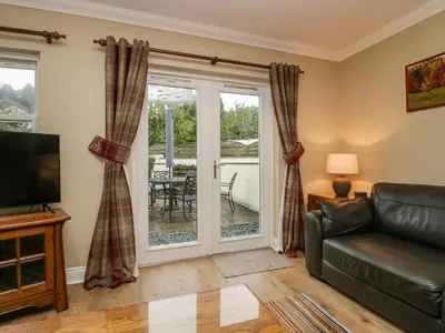 a living room with a couch and a sliding glass door at Castle Crag in Keswick