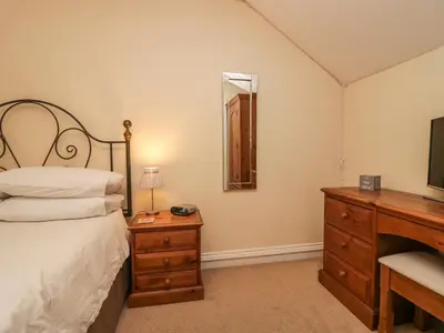 a bedroom with a bed and a dresser and a mirror at Castle Crag in Keswick