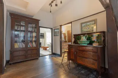 a living room with a wooden dresser and a hallway at Goody Bridge Barn in Grasmere