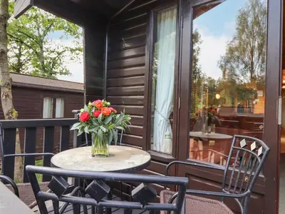 a vase of flowers sitting on a table on a porch at Ennerdale Lodge in Keswick