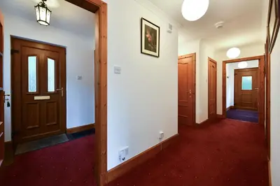 an empty hallway with wooden doors and red carpet at North Blairkip Eildon in Sorn