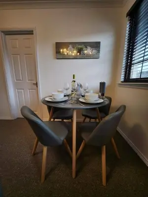 a dining room table with chairs and wine glasses at 10 Ladyknowe court in Moffat